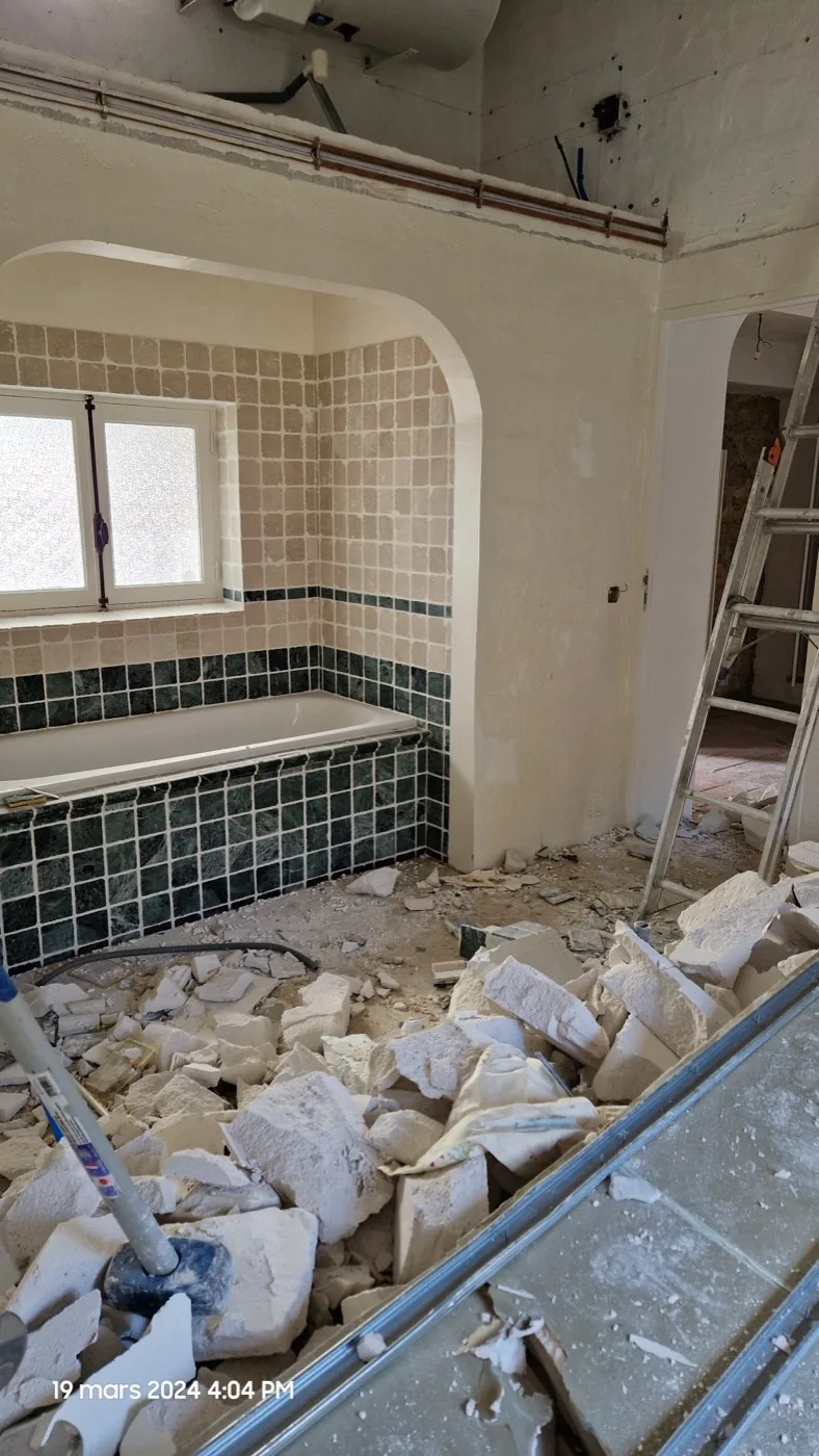 Salle de bain en cours de rénovation par Atlas Construction, dépose du carrelage existant