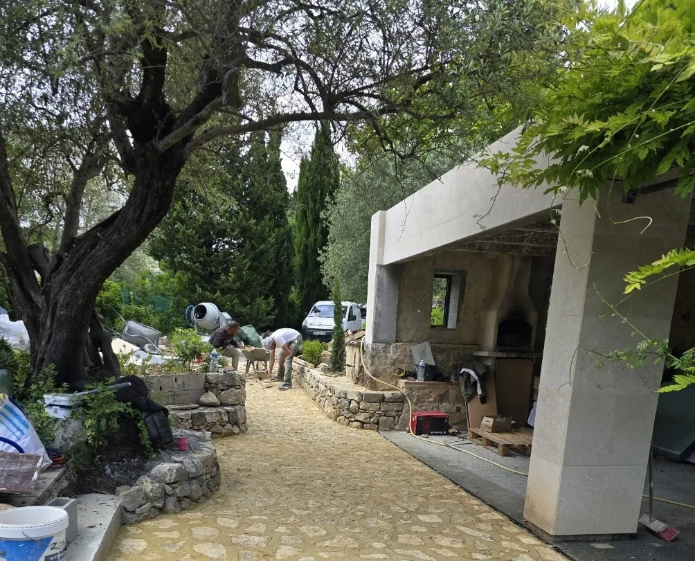 Sol en pierre naturelle posé par Atlas Construction devant une cuisine d'été en Provence